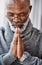 Hes praying for some much needed guidance. a handsome senior man praying in his home.