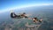 A heterosexual couple of skydivers kiss while free falling, on a summer day.