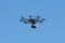 Hexacopter drone with camera in action on blue sky