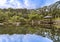 Hexagonal Gazebo Ukimido in the central pond of Mejiro Garden where ducks are resting and which is surrounded by large rocks and