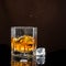 Hexagonal glass of whiskey with ice on a dark background and a number of real ice cubes