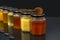 Hexagonal jars with different types and colors of fresh flower honey and a honey spoon. vitamin food for health and life