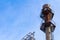 Hexagonal platforms connected by ladders on a huge smokestack, decaying industrial complex, blue sky copy space