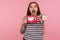 Hey you, click Like and follow my blog! Portrait of blogger woman in striped sweatshirt holding social media Heart button