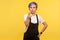 Hey you! Portrait of hipster woman pointing at camera and looking strict rigid. yellow background, studio shot