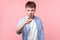 Hey you! Portrait of suspicious serious brown-haired man pointing at camera. indoor studio shot  on pink background