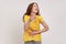 Hey, you are ridiculous. Teenager girl in yellow T-shirt laughing, holding stomach and pointing