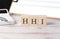 HHI word on a wooden block with clipboard and calcuator