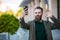 Hi there. Man smiling taking selfie photo smartphone urban background. Streaming online video call. Mobile internet. Hipster