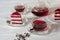 Hibiscus tea in cups and teapot, tea leaves, for dessert red velvet cake pieces on white wooden background.