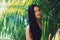 Hidden beauty of a tropical garden. Portrait of an attractive young woman posing against a leafy background.