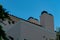 Hidden house facade in secret garden with visible trees and beige or cream stucco exterior with chimneys