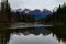 Hidden pond showing reflections of mountains with ice forming on pond