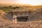 Hierapolis ancient city Pamukkale Turkey, young woman with hat watching sunset by the ruins Unesco