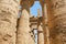 Hieroglyphs and ancient symbols on the columns of the Temple of Karnak, row of pillars in perspective