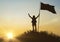 High achievement, silhouettes. Against the dramatic sky with clouds at sunset.