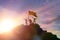 High achiever, silhouettes of three people holding on top of a mountain to raise their hands up.