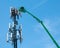 High in the air, workmen maintain a cell tower