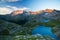 High altitude alpine lake, dams and water basins in idyllic land with majestic rocky mountain peaks glowing at sunset. Wide angle
