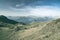 High altitude pasture, rocky mountain peaks and jagged ridge, with scenic sky, the Italian Alps. Expansive view in backlight. Tone