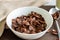 High angel view of chocolate cereal in a white bowl on brown background