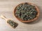 High angel view of dry mugwort on wooden plate and spoon. Chinese herbal medicine.