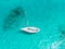 High angle aerial drone bird`s eye view of a sailing yacht with sails lowered anchored in shallow, turquoise water