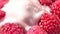 High angle amazing tasty dessert fresh red raspberries pouring viscous white yogurt or milk or cream