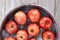 High angle closeup of a metal tub filled with water and apples for the Halloween custom of Apple Bobbing