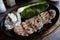 High angle closeup shot of fine cuts of meat on a black plate