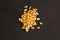 High angle closeup shot of a pile of peeled yellow corns on a black background