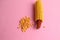 High angle closeup shot of a pile of peeled yellow corns on a pink background