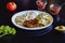 High angle closeup shot of a plate of eggs, crushed beans and chilaquiles on a black table