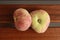 High angle closeup shot of two saturn peaches on wooden planks