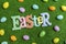 High angle of Easter banner letters with scatter plastic Easter eggs