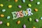 High angle of Easter letters banner with scattered plastic eggs