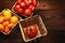 High angle image of produce baskets filled with a variety of medley tomatoes. Horizontal with warm side light and copy space