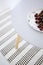 High angle on plate with cherries on grey table in apartment interior with patterned rug. Real photo