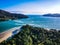 High angle shot of an amazing view of wavy sea with mountains and dense trees around it.