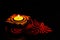 High angle shot of beautiful brass lamp and red kumkum rangoli on black background with copy space. diwali concept