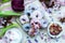 High angle shot of blue and purple vegan donuts on a table surrounded by flowers