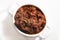 High angle shot of a bowl of meat and vegetable soup on a white surface