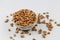 High angle shot of a bowl of peanuts on a white surface