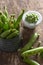 High angle shot of a ceramic bowl of peas next to pea pods in a metal container