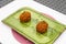 High-angle shot of cheese falafels on a green plate served at a local Japanese restaurant