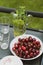 High angle shot of cherries plate near mint lemonade on a black table