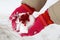 High angle shot of a child with gloves holding the snow with berries on it