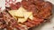 High angle shot of chorizo and Jamon serrano slices with cheese on a plate on the table