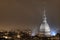 High angle shot of a cityscape enveloped in night lights and a big dome building in Turin, Italy