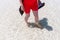 High angle shot of a female stepping in the transparent water of the sea at San Teodoro, Sardinia